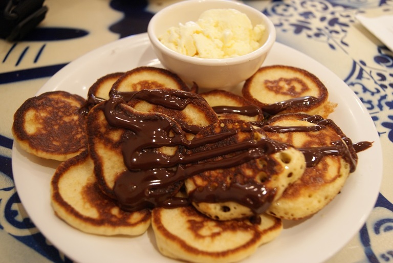 assiette avec mini pancakes sauche chocolat et boule de glace vanille