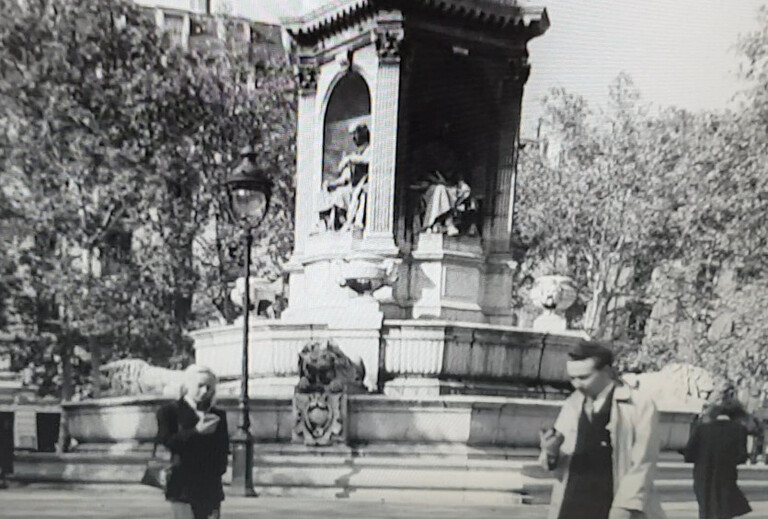 scène en noir et blanc avec homme et femme devant un monument