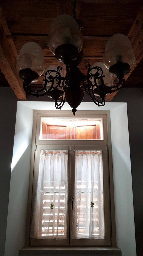 fenêtre avec volets fermés et vieux lustre