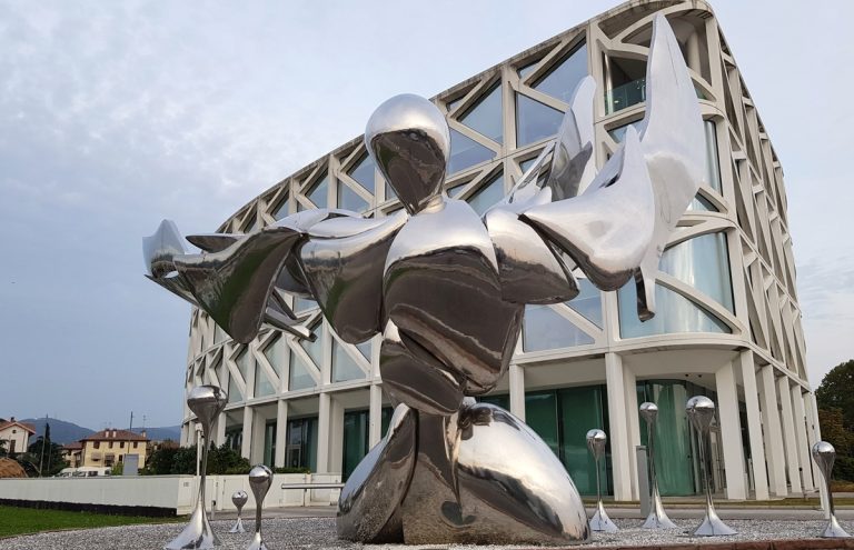 statue moderne devant immeuble façade en verre